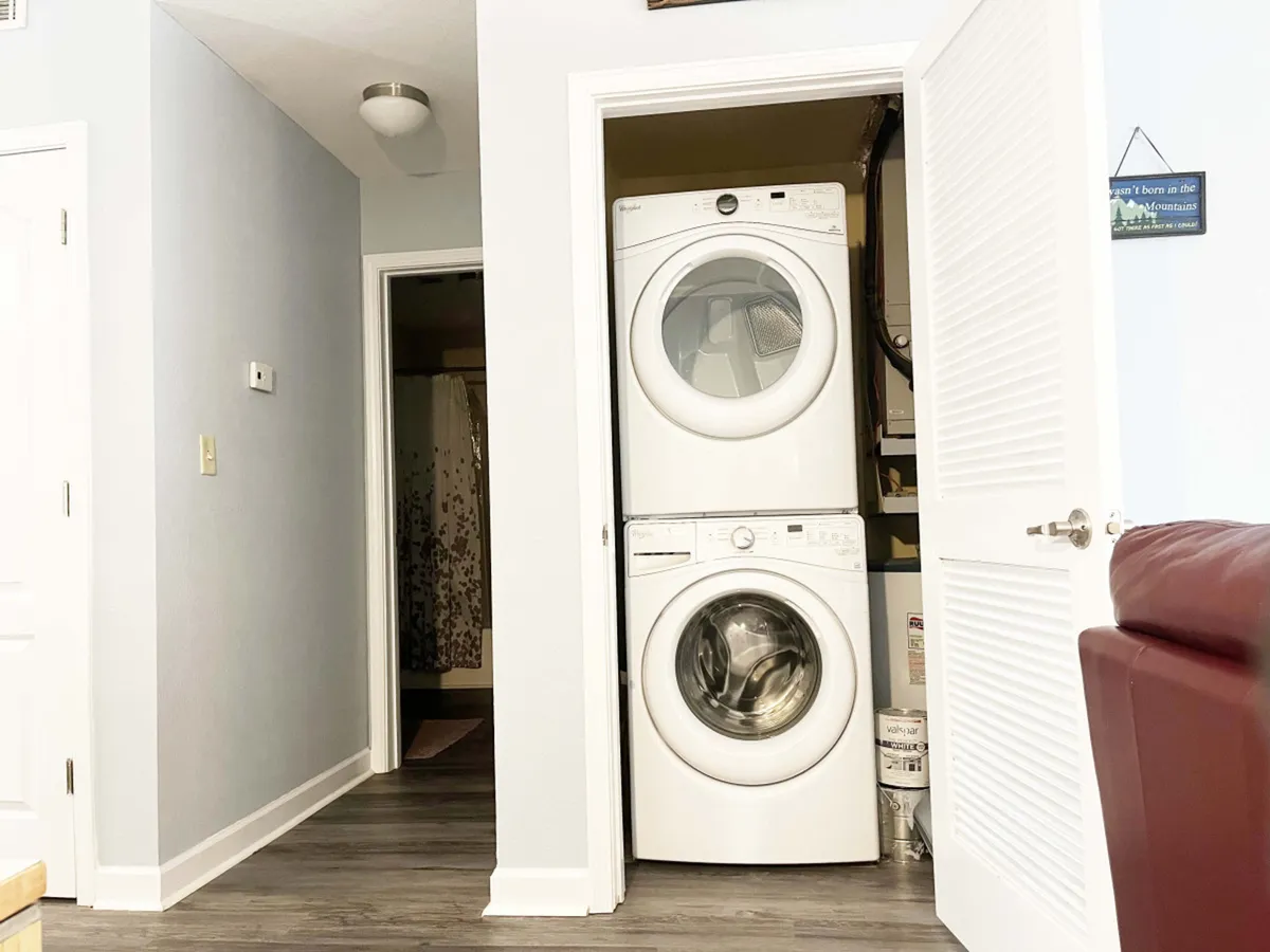 A tidy laundry nook featuring an in-unit washer and dryer, with a convenient doorway to the bathroom. The space is practical, uncluttered, and ready for guests to handle their laundry needs with ease.